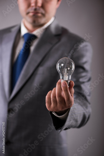 Businessman holding light bulb in creativity concept