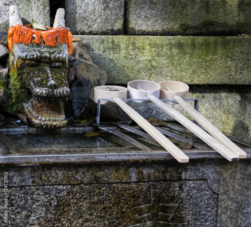Chozuya purification fountain ladles. Traditional Japanese Shinto wash basin for ritual cleaningof worshipers at the shrine entrance. photo