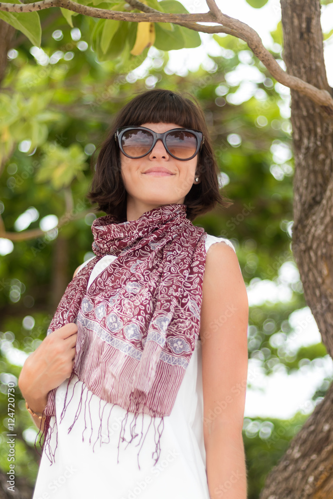 Beauty portrait of sexy brunette woman in white dress on the beach with colorful silk scarf and sunglasses. Cruise summer fashion. Bali, Indonesia. Beauty portrait of sexy brunette woman in white dress on the beach with colorful silk scarf and sunglasses. Cruise summer fashion. Bali, Indonesia.