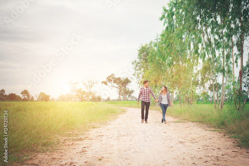 Young hipster couple walking on rural road enjoying with nature, © Johnstocker