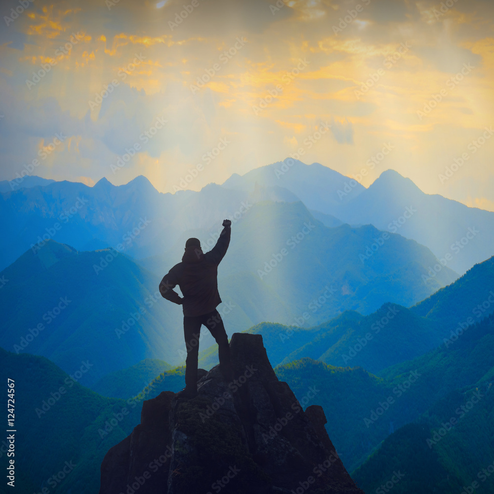 Silhouette of winner standing on a cliffs edge