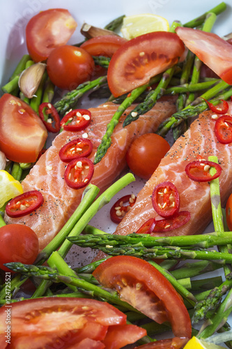 Tasty pieces of salmon with green asparagus, tomato and red pepper