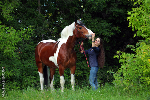 Beauty model hugging a horse in nature background