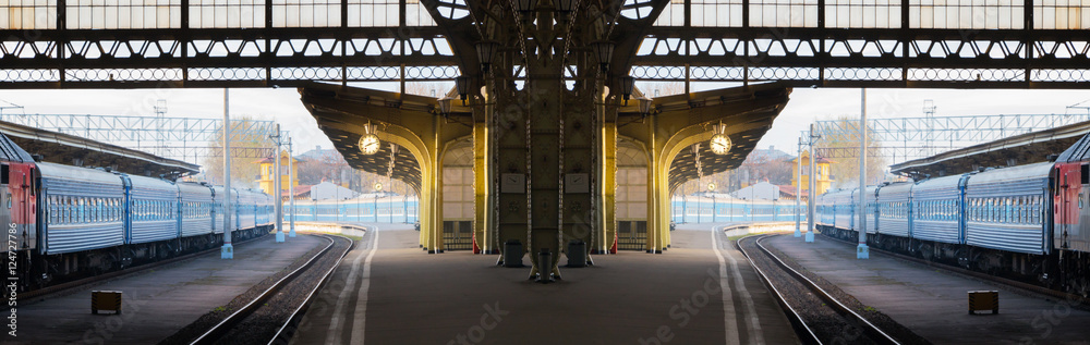 Fototapeta premium Concept of time, changes, travel. Deserted morning railway station. Wide panoramic scenic composition.