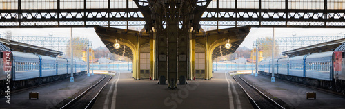 Concept of time, changes, travel. Deserted morning railway station. Wide panoramic scenic composition.