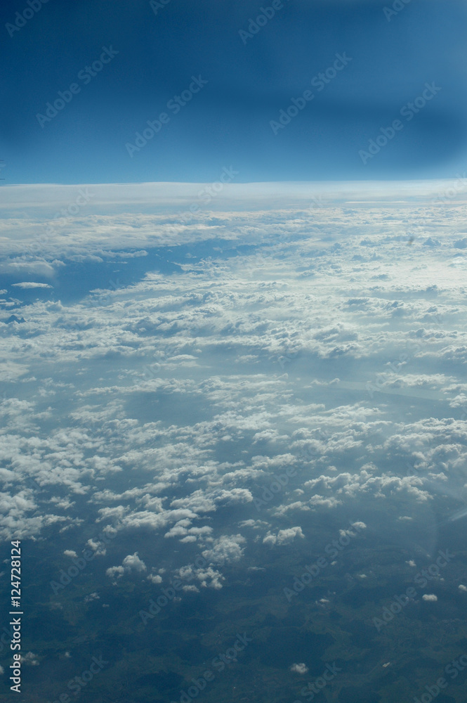 Couche de nuages vue à travers un hublot passager d'un avion de ligne en vol