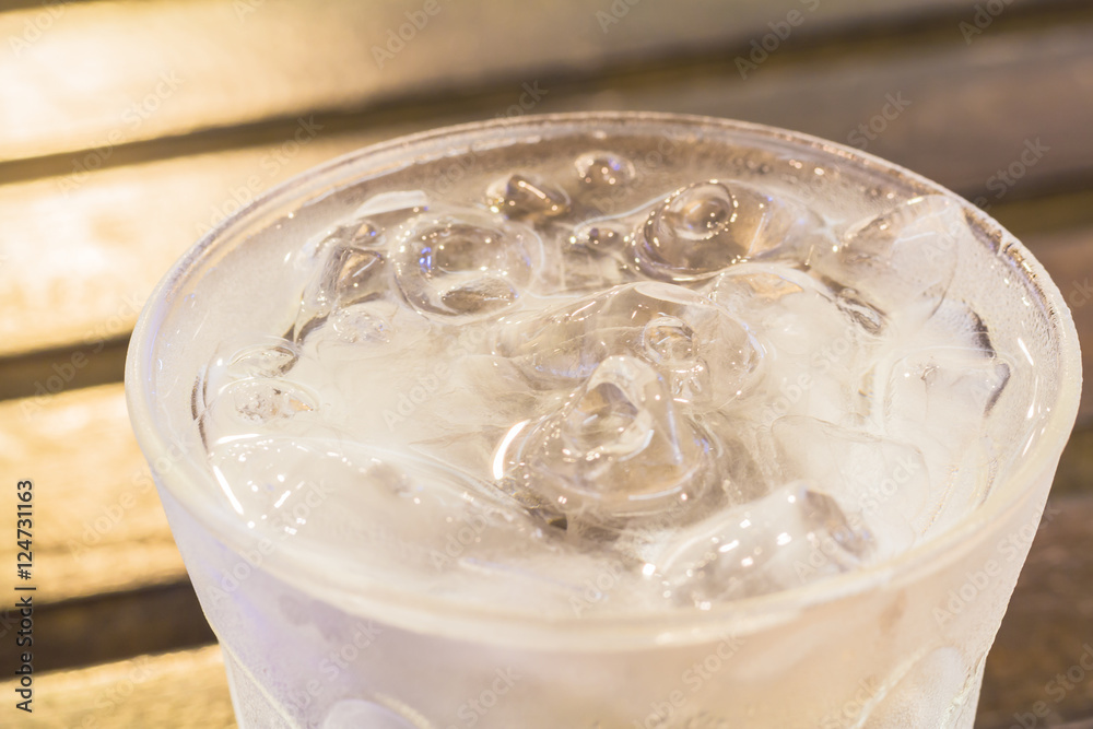 Glass of water with ice on a table in a restaurant.