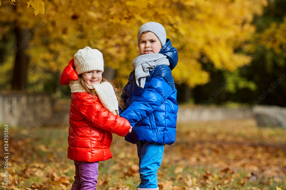 Children in yellow autumn park. Little boys and a girl standing Children in yellow autumn park. Little boys and a girl standing