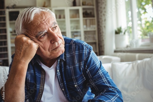 Worried senior man sitting on a sofa