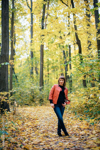 girl walking in the autumn yellow wood, maple grove