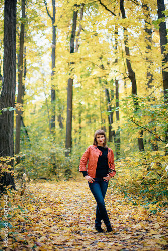 girl walking in the autumn yellow wood, maple grove