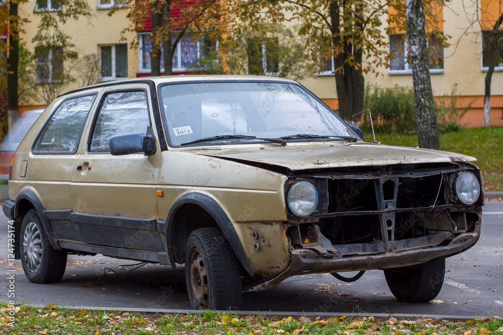 broken car abandoned in a Parking lot