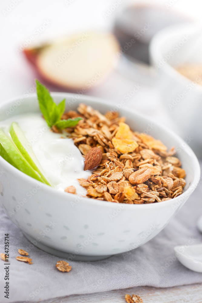 Granola with yogurt and apples in a bowl for breakfast, closeup Granola with yogurt and apples in a bowl for breakfast, closeup