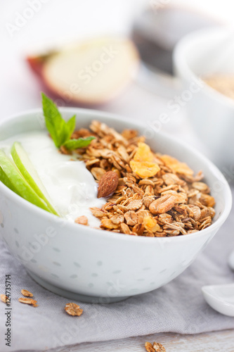 Granola with yogurt and apples in a bowl for breakfast, closeup