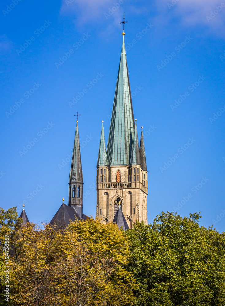 Herz-Jesu-Kirche mit Herbstwald und blauem Himmel - Paderborn, Deutschland.