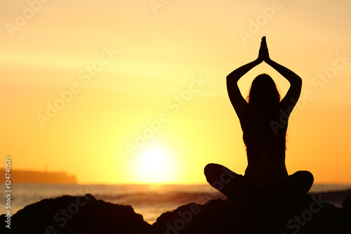 Woman silhouette doing yoga exercises