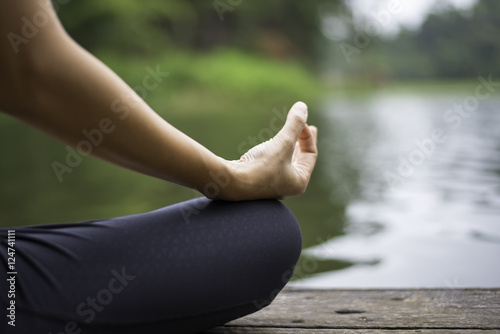 Close up hand. Woman do yoda outdoor. Woman exercising yoga at the nature background, select focus