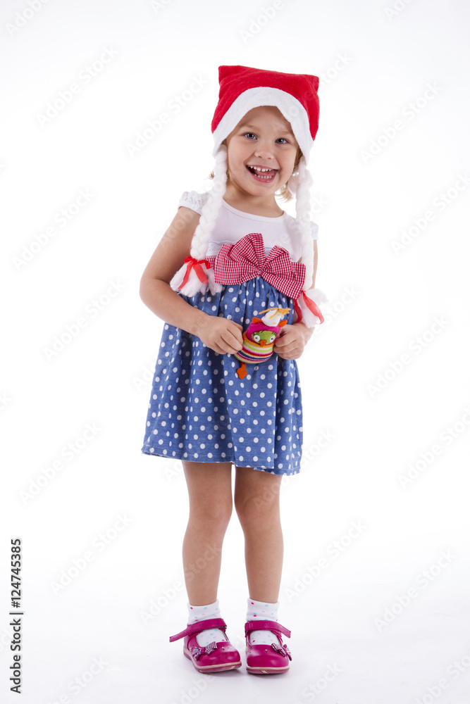 Girl in santa hat. in full growth in polka-dot dress with a toy owl in the hands of the playful toddler Girl in santa hat. in full growth in polka-dot dress with a toy owl in the hands of the playful toddler