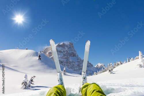 Detail of alpine skier legs, watching the valley panorama