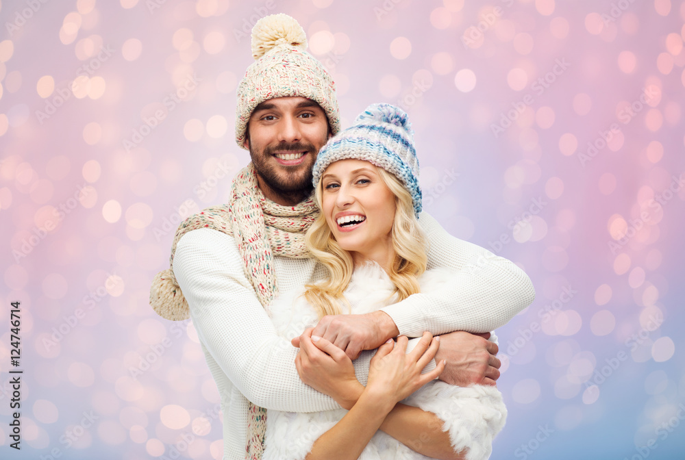 smiling couple in winter clothes hugging