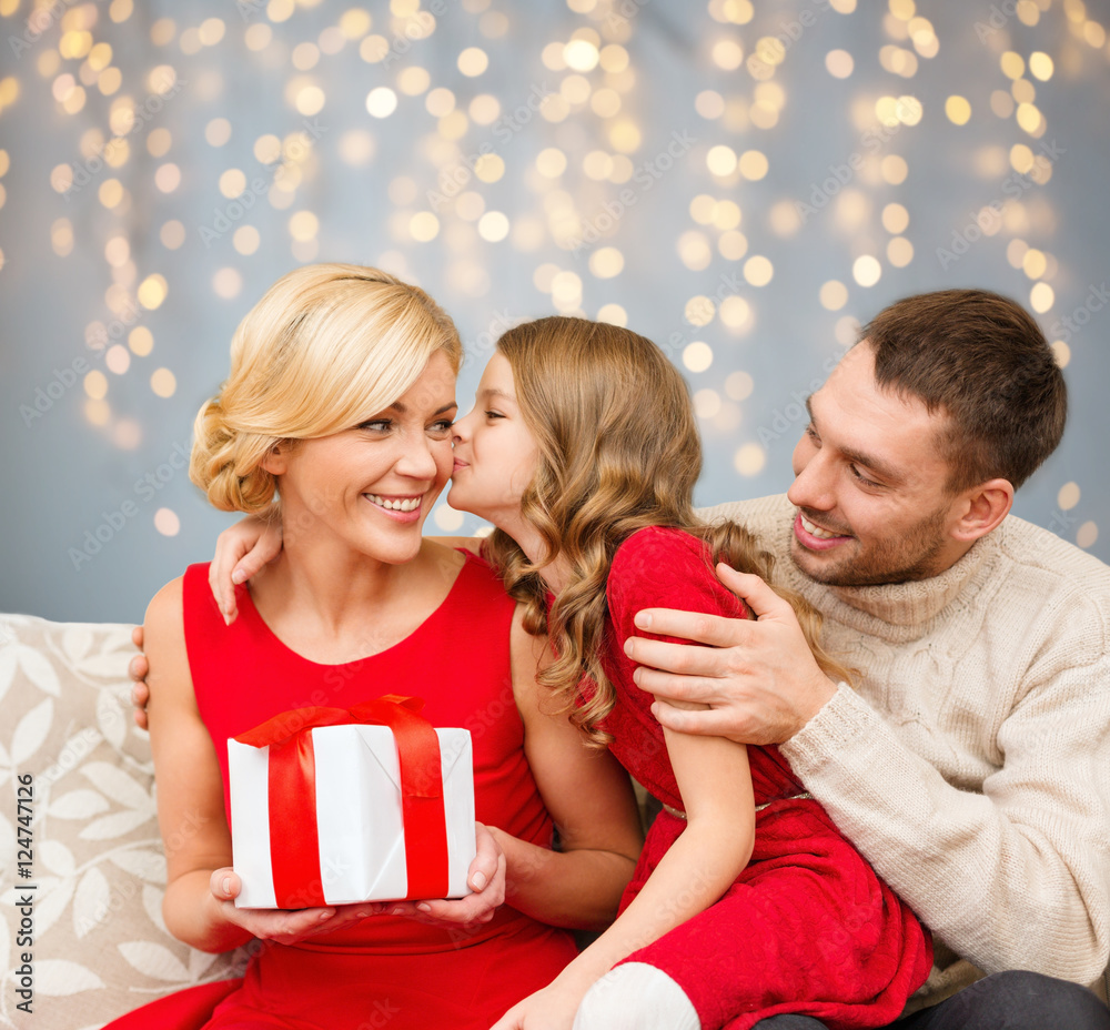 happy family with christmas gift kissing