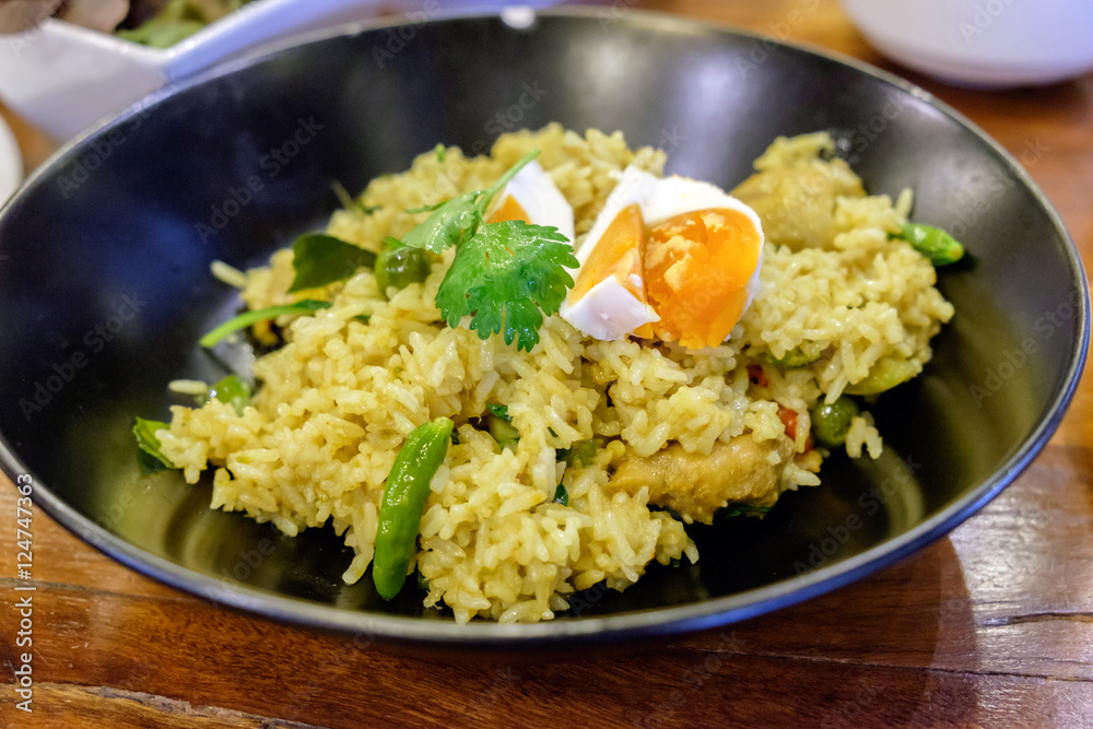 Rice yellow green curry with boiled egg in black dish Rice yellow green curry with boiled egg in black dish