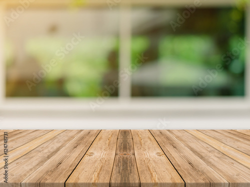 Wooden board empty table top on of blurred background. Perspective brown wood table over blur in coffee shop background - can be used mock up for montage products display or design key visual layout.