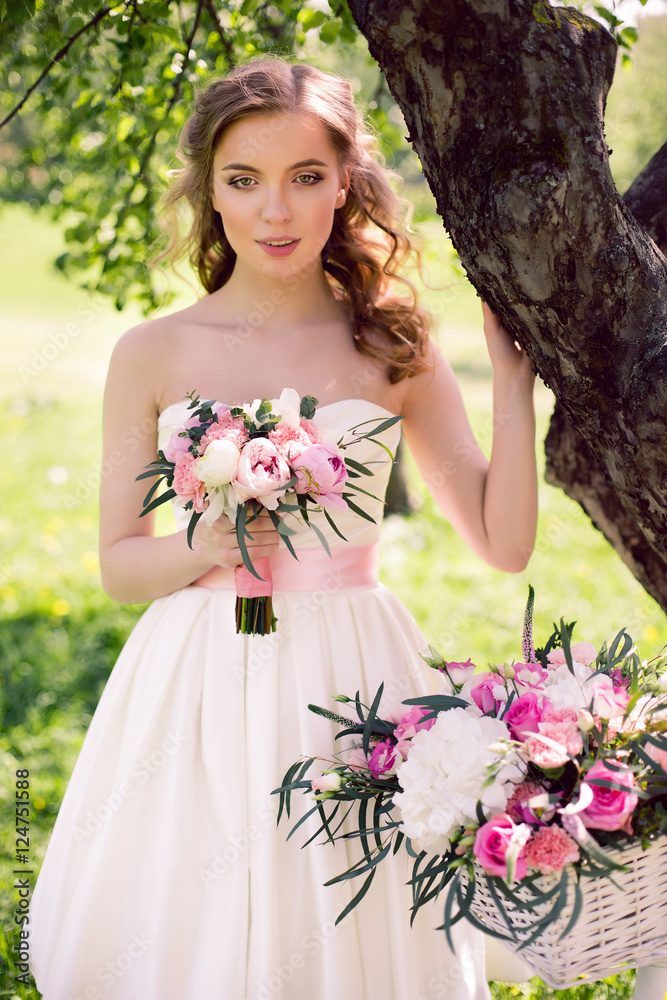 young bride in white dress and with a bouquet in the summer young bride in white dress and with a bouquet in the summer
