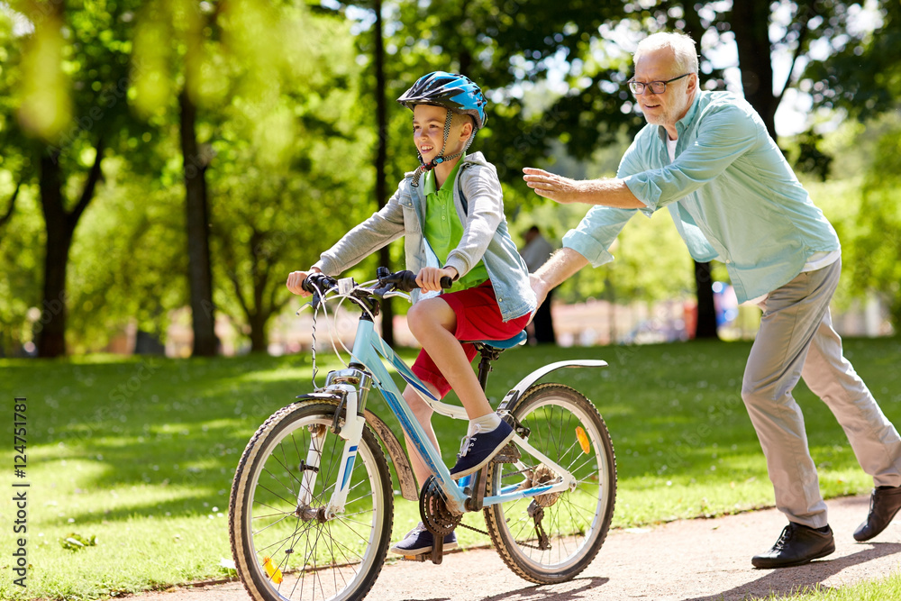 grandfather and boy with bicycle at summer park grandfather and boy with bicycle at summer park