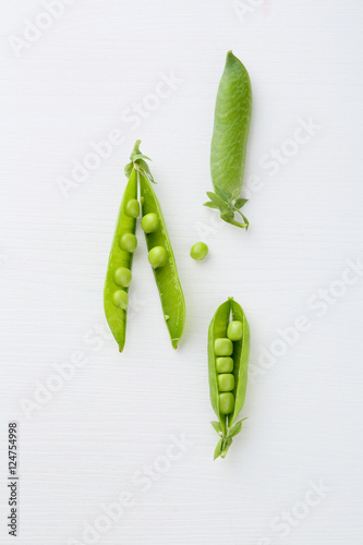 Fresh green peas on white wood background