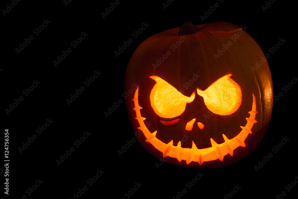 Scary Halloween pumpkin isolated on a black background. Scary glowing face trick or treat