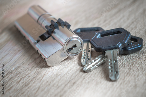 door lock with keys on wooden surface