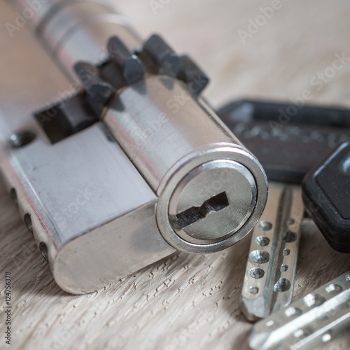 door lock with keys on wooden surface
