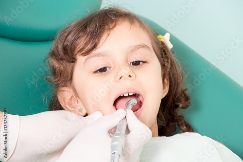Фотография Dentist examining girl's teeth at dental clinic