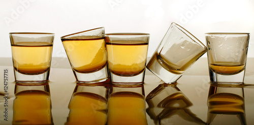 Whiskey in shot glasses tipped and spilled
