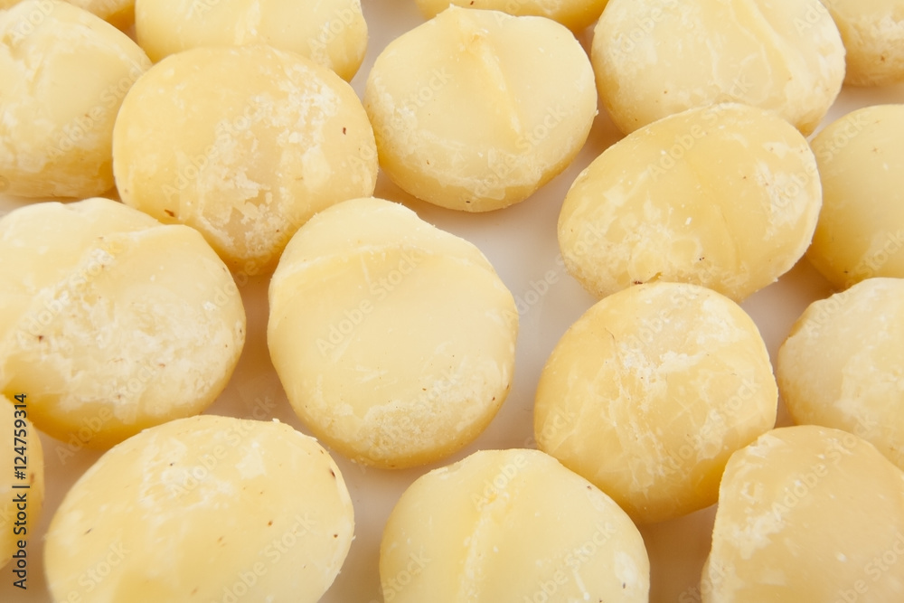 delicious macadamia nuts on  plate on  wooden background