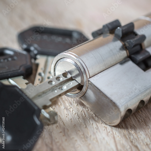 door lock with keys on wooden surface