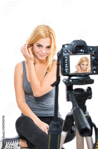 Woman blogger relieves herself on camera. On white, isolated background.