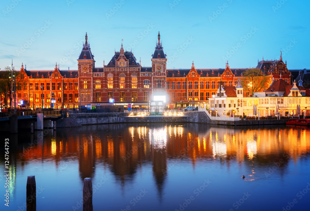 cityscape with central railway station and old town canal illuminated at night, Amsterdam, Holland, retro toned