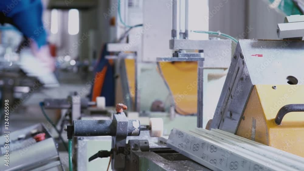 PVC Windows and Doors Manufacturing. PVC sections of windows and doors in a single frame - finishing process, releasing small window for the next step. PVC Windows and Doors Manufacturing. PVC sections of windows and doors in a single frame - finishing process, releasing small window for the next step.