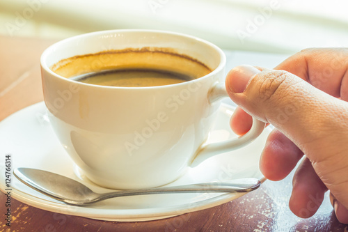 Man's hand holding a cup of coffee.