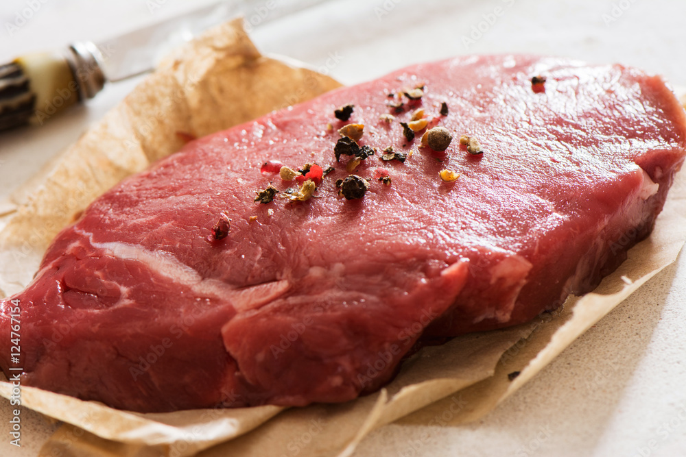 Raw beef tenderloin with peppercorns Raw beef tenderloin with peppercorns