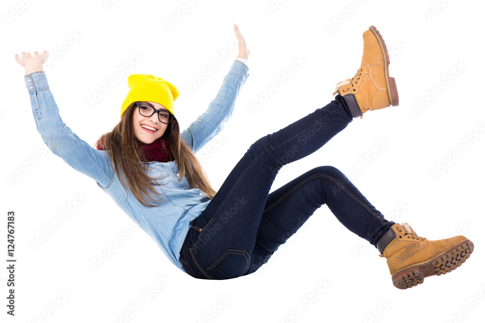 funny teenage girl falling down in winter clothes isolated on wh