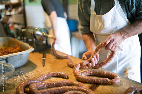 Fotografía Men making sausages the traditional way using sausage filler.