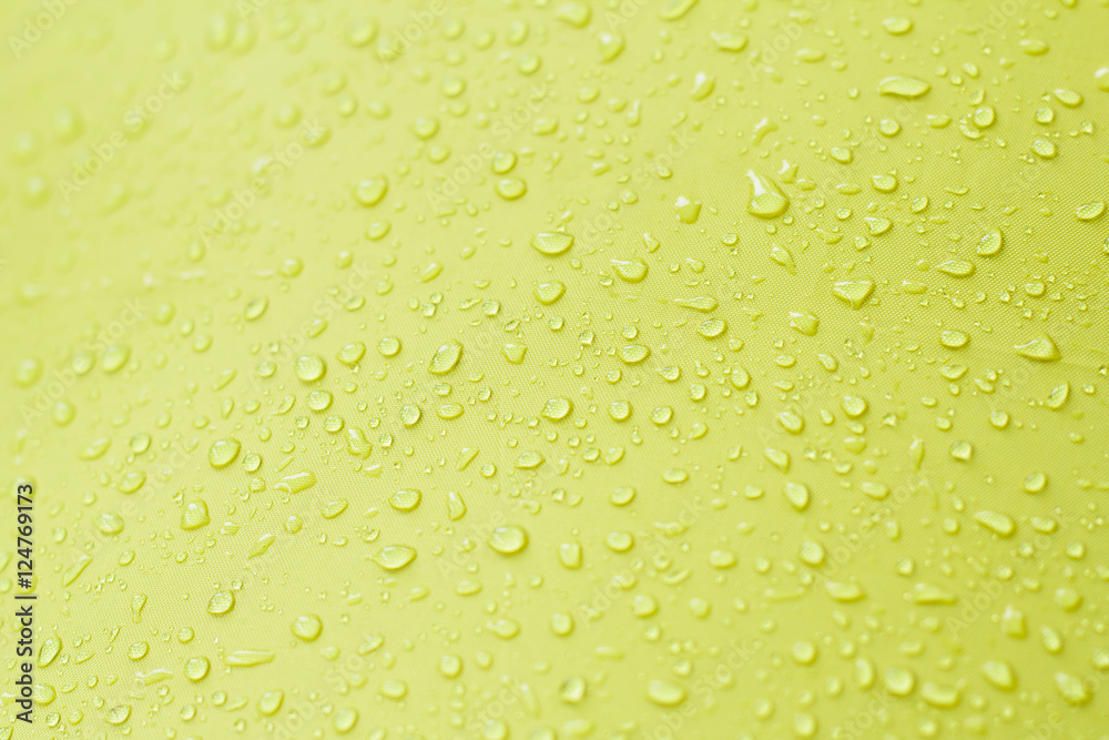 Drop of water on yellow background