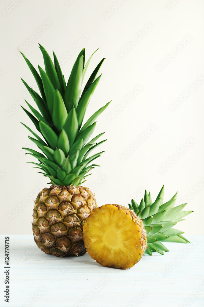 Ripe pineapples on a white wooden background