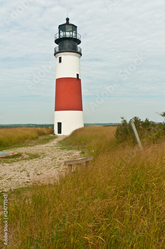 Active lighthouse on a grassy cliff on a north Atlantic barrier island