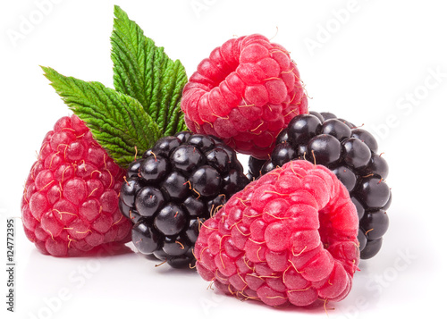 Canvas Print pile of raspberries and blackberries with leaves isolated on white background
