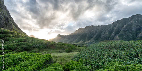 Sunset Between lush green Hawaiian valley with Moody sky photo