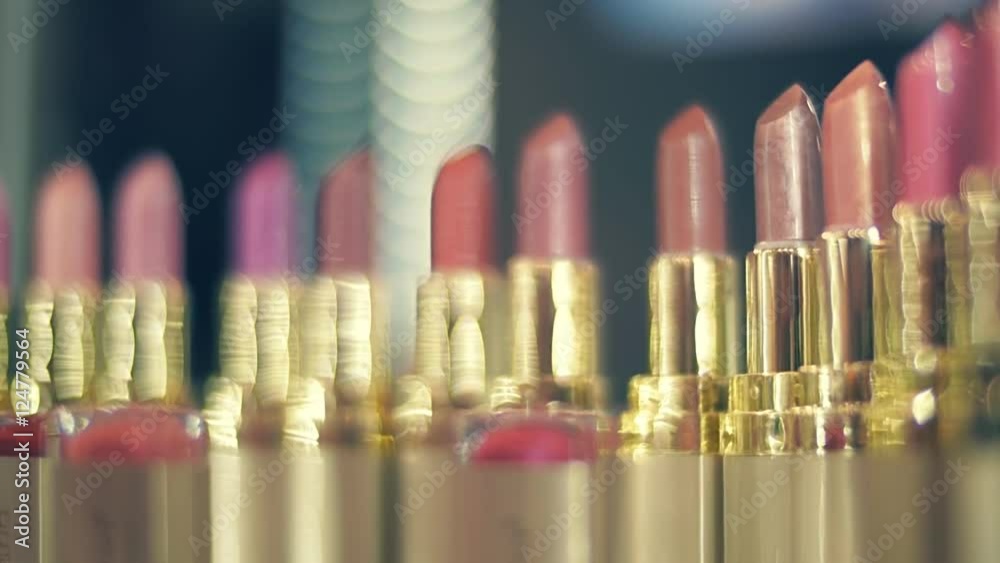 Lipstick variety of colors and shades in the shop window sparkle in the rays of light. Closeup. Shallow depth of field. Dolly shot Lipstick variety of colors and shades in the shop window sparkle in the rays of light. Closeup. Shallow depth of field. Dolly shot